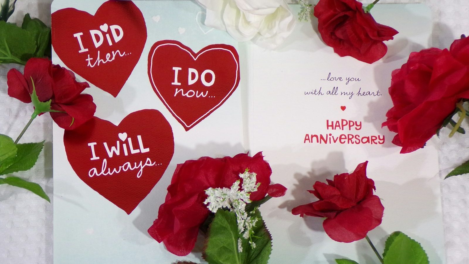 Heart-shaped anniversary notes surrounded by red roses